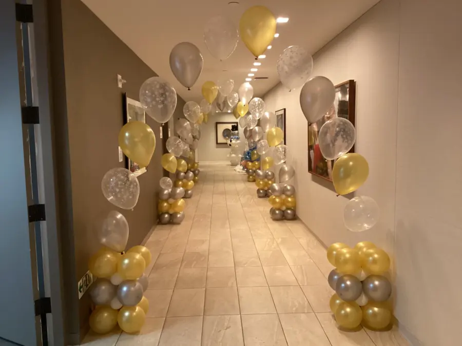 Gold, silver and snowflake print balloon arches lining a hallway, New Jersey