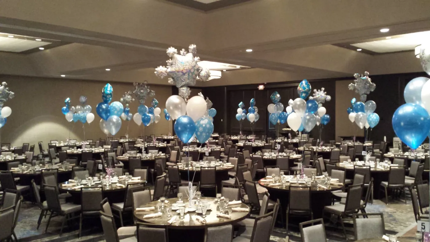 Blue, silver and white balloon centerpieces with snowflake foil toppers across a New Jersey ballroom