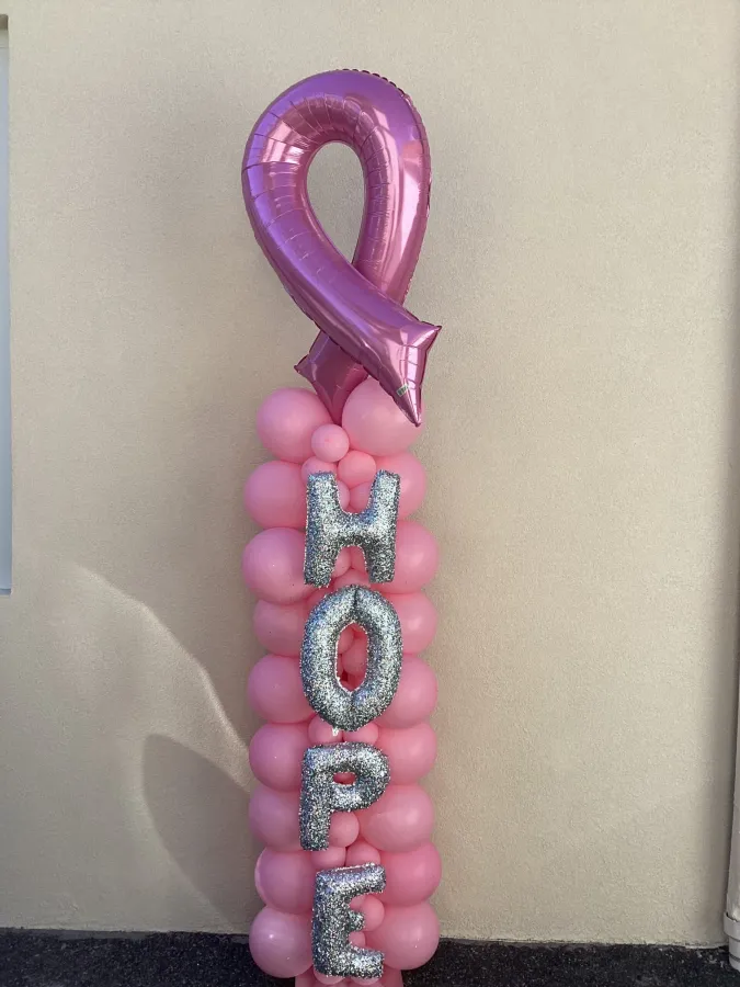 Pink HOPE foil letter balloon column with a pink ribbon topper
