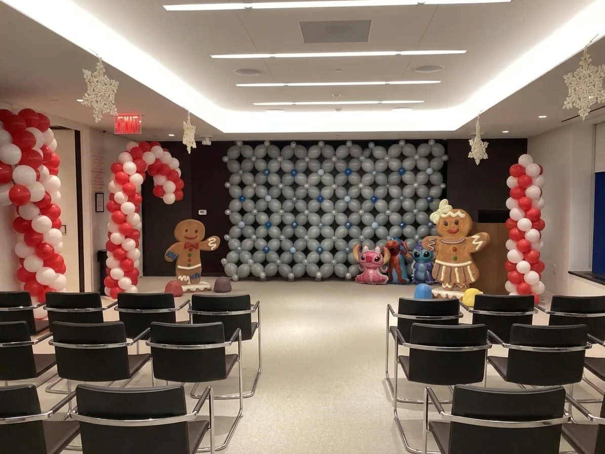Candy cane balloon columns and a silver balloon wall at a Christmas event, New Jersey