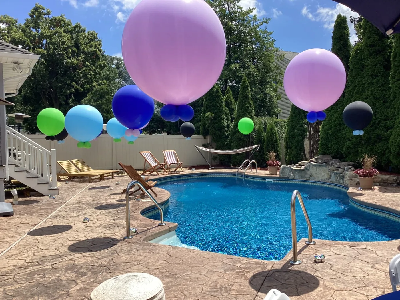 Giant jumbo balloons floating over a backyard pool party, New Jersey