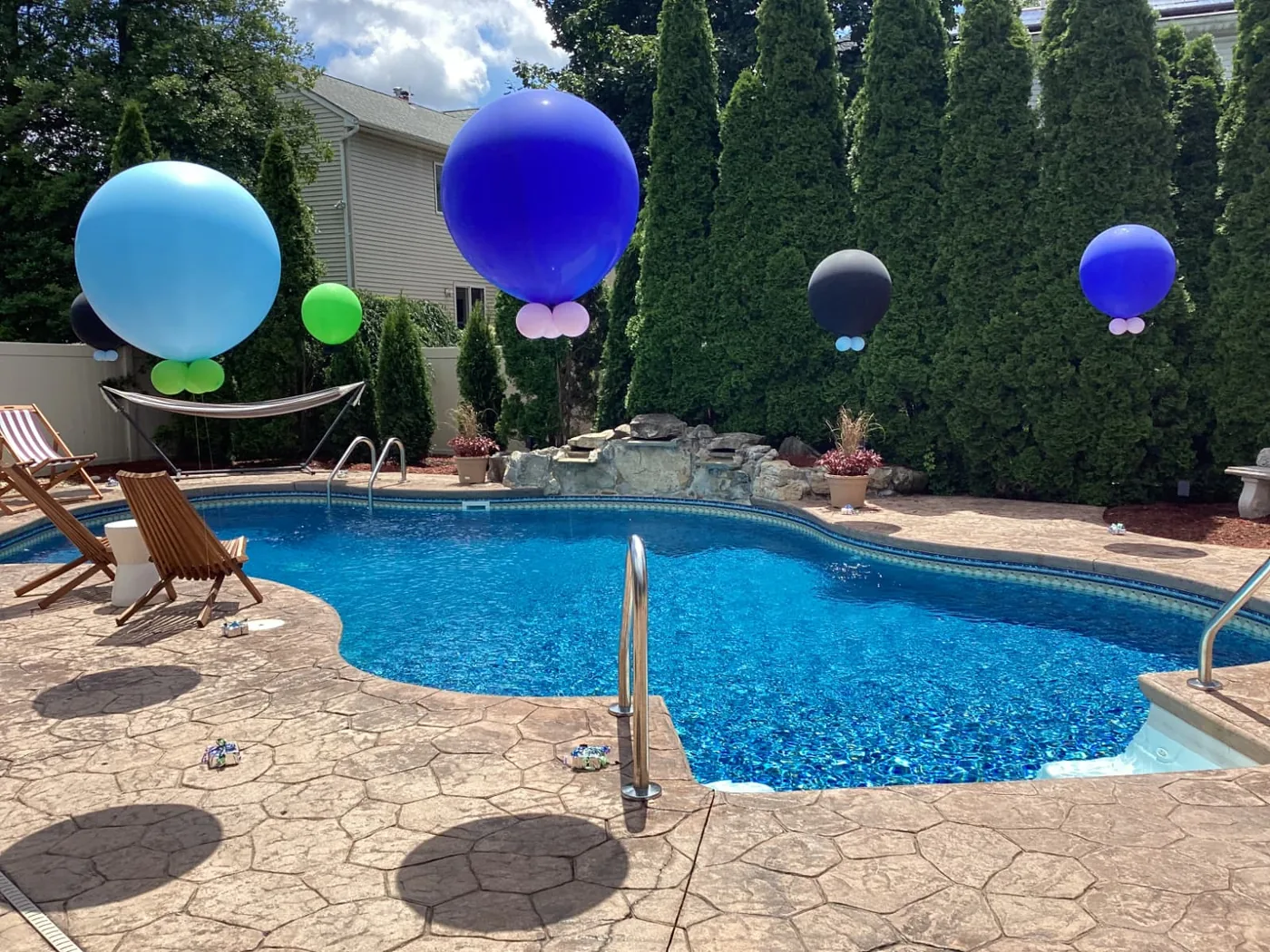 Jumbo blue and green balloons around a pool in New Jersey