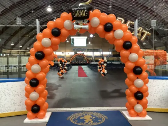 Orange and silver balloon arch at an ice rink event, New Jersey