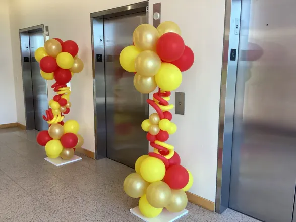 Organic red, yellow and gold balloon columns with twisted spirals beside lobby elevators, New Jersey