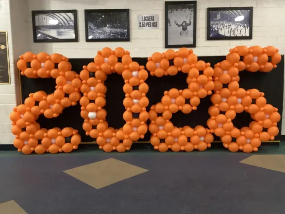 Giant freestanding orange 2026 balloon numbers in a school gym, New Jersey